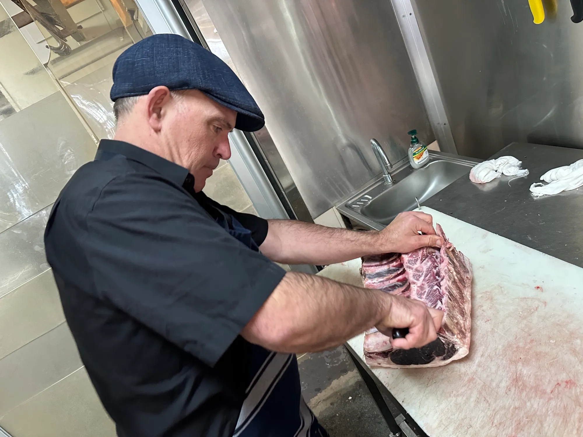 A butcher trimming ribs on the block