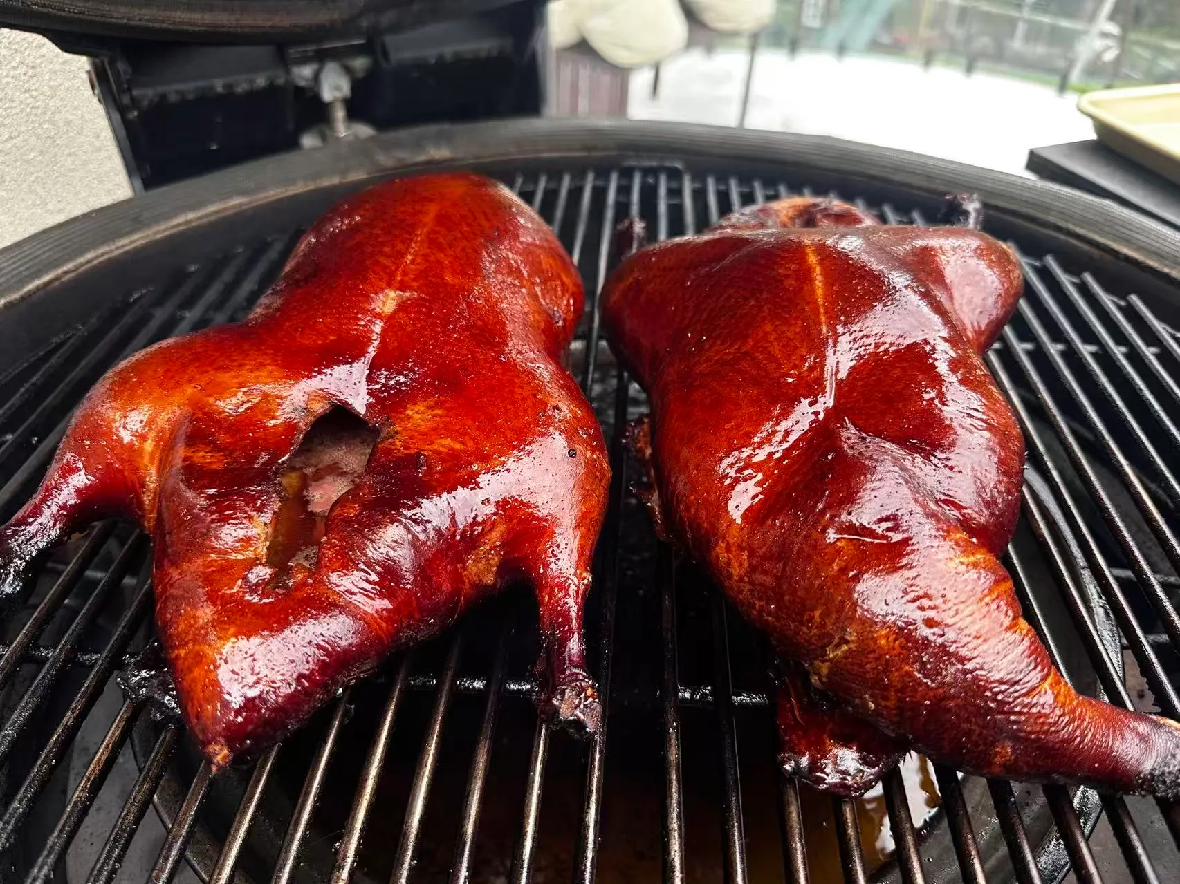 Two halves of charcoal-roasted duck on the grill