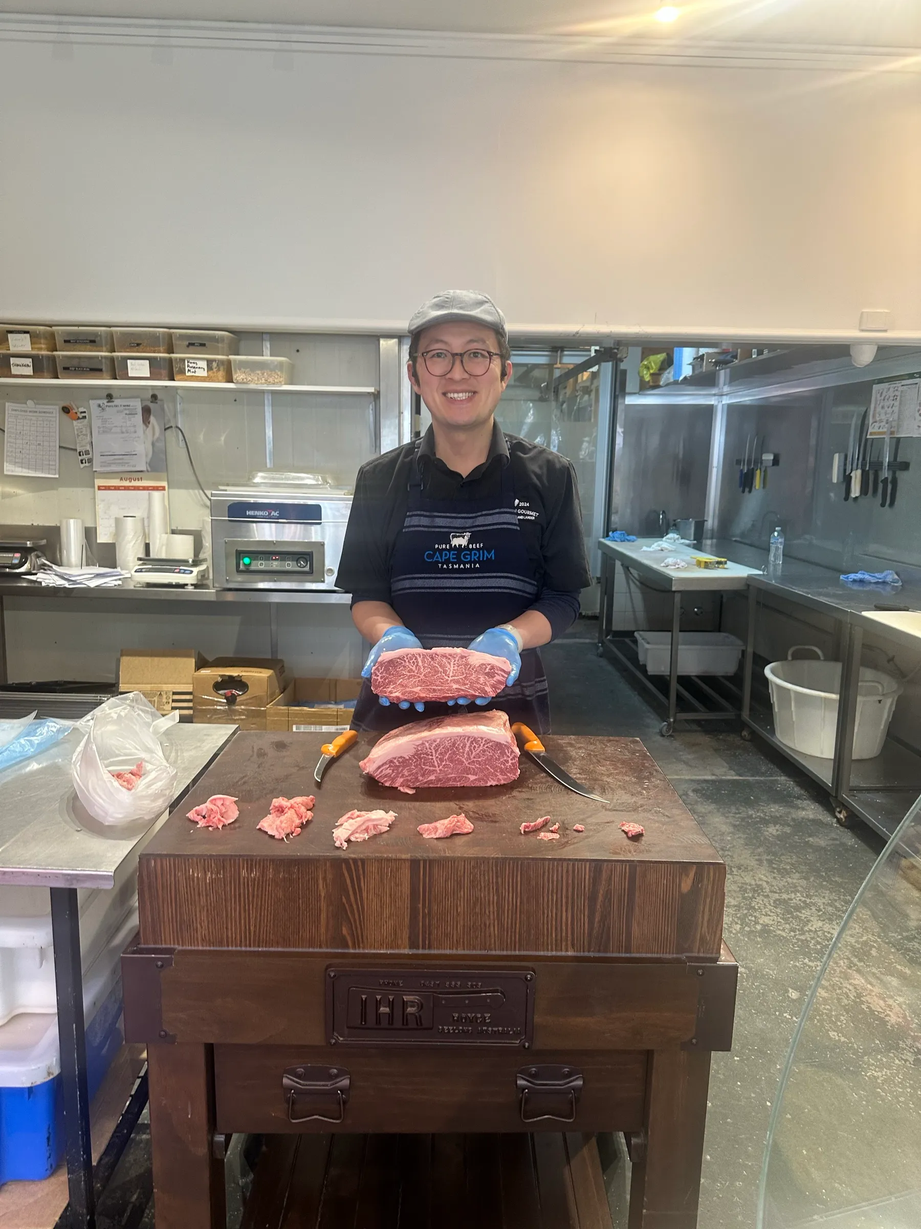 Will Yu behind the counter holding a whole scotch fillet