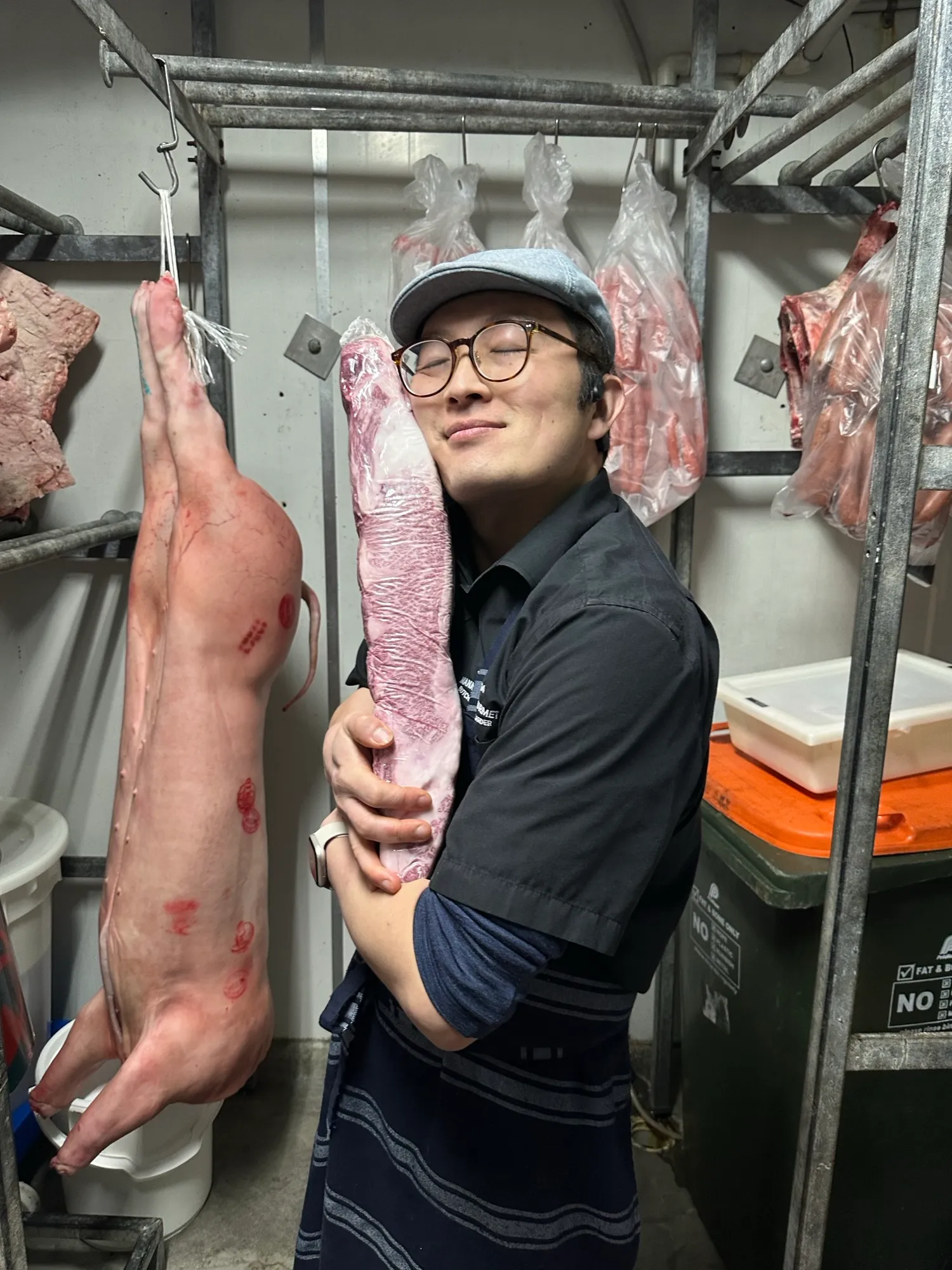 A team member in the cool room with hanging cuts
