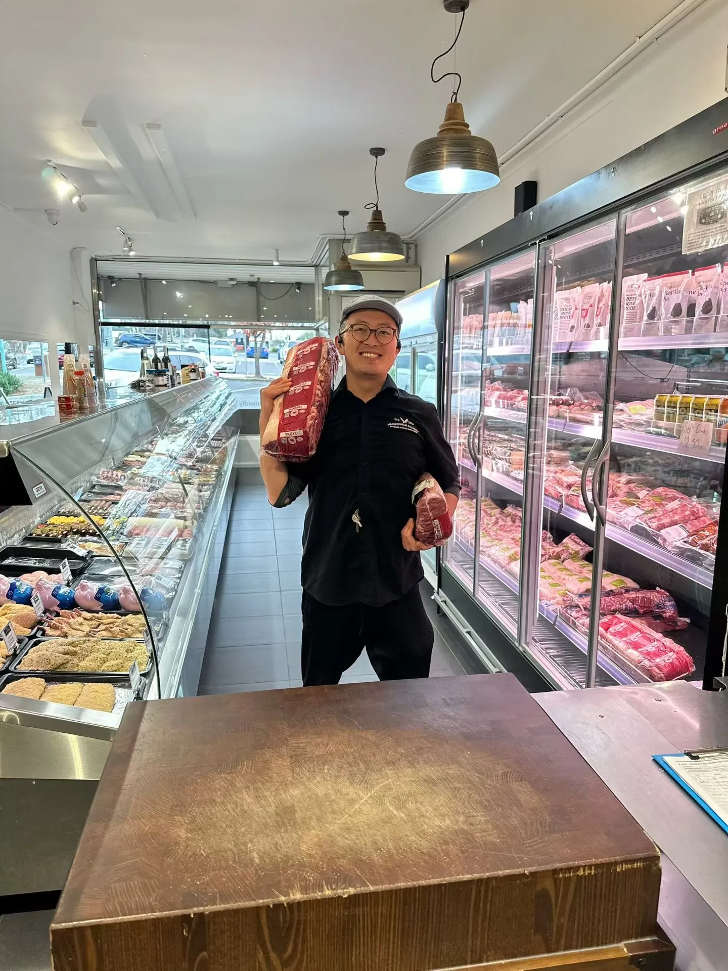 Will Yu inside the shop, holding a whole Wagyu cut
